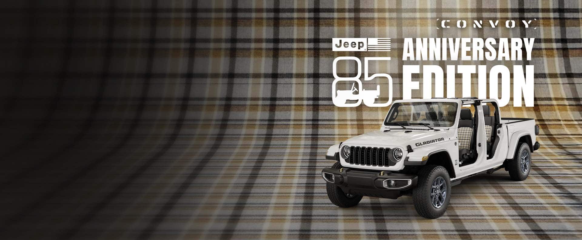 A driver-side front angle of a white 2026 Jeep Gladiator 85th Anniversary Edition with its doors and top removed, revealing plaid inserts on the front and rear seats, parked on a seamless plaid surface that extends up the wall behind it. Jeep 85 Anniversary Edition. Convoy.