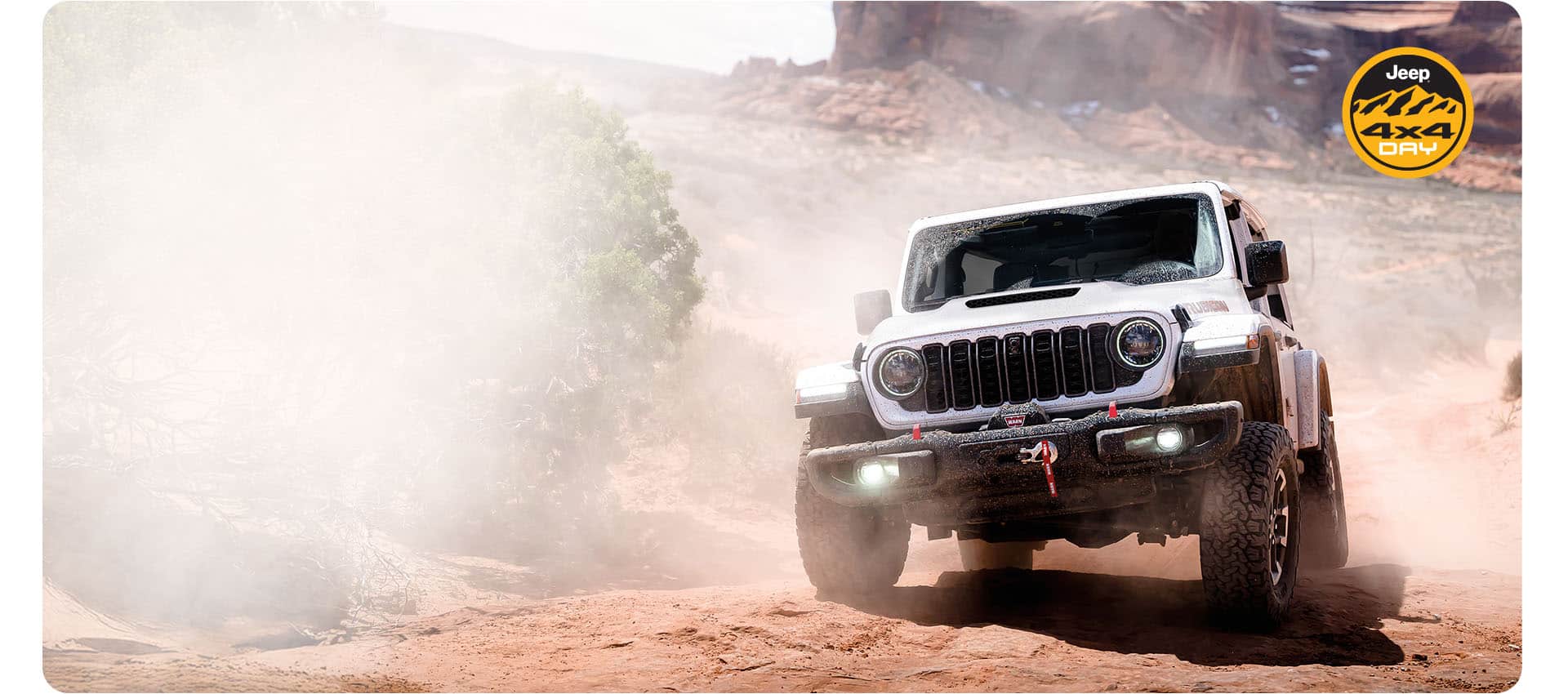 A white 2026 Jeep Wrangler Rubicon X descending a hill off-road. Jeep 4x4 Day.