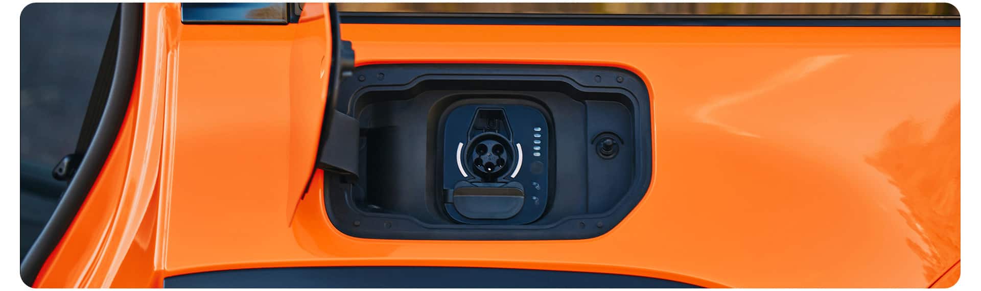 The charging port on an orange 2026 Jeep Recon.