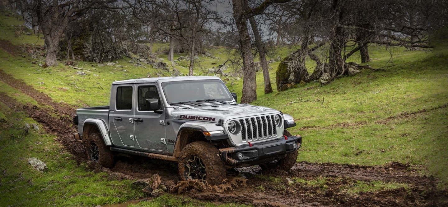 Jeep Gladiator Rubicon 2023 este condus off-road pe o pantă noroioasă.