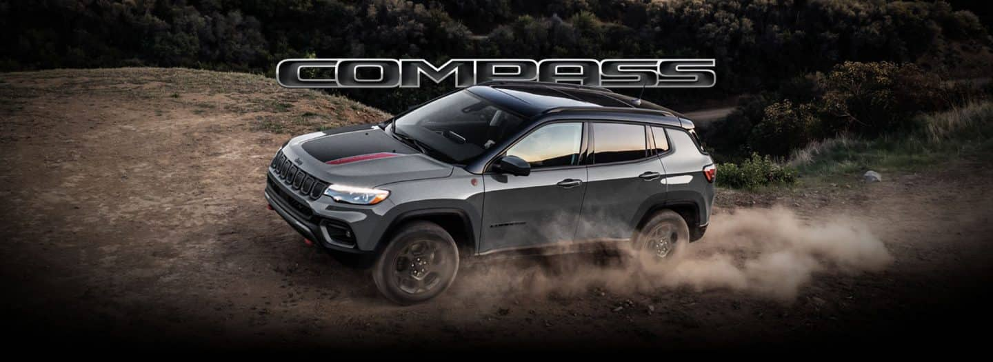 Un Jeep Compass Trailhawk din 2024 este condus pe un deal off-road, cu anvelopele făcând praf. Busolă.