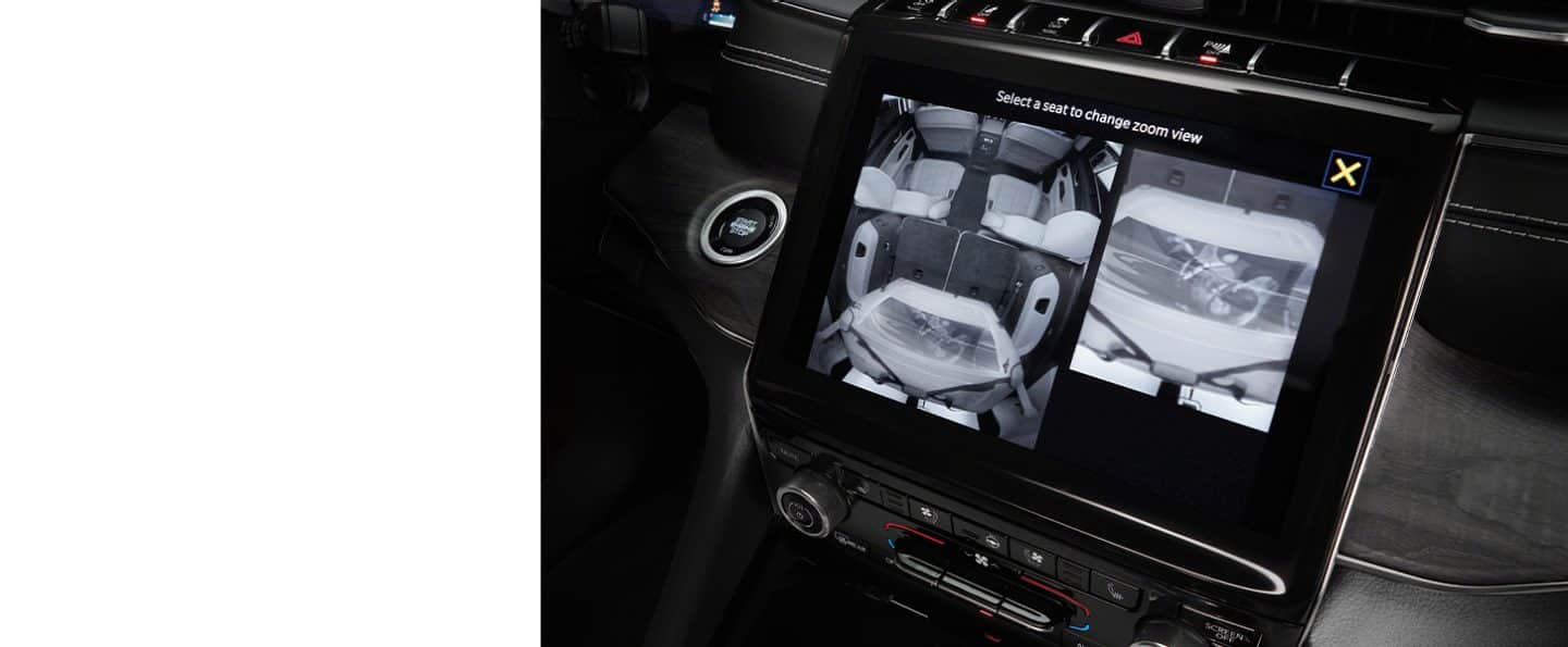 La pantalla táctil Uconnect del Jeep Grand Cherokee 2024 muestra la salida de la cámara de vigilancia de los asientos traseros, con una pantalla dividida tanto para la segunda como de la tercera fila.