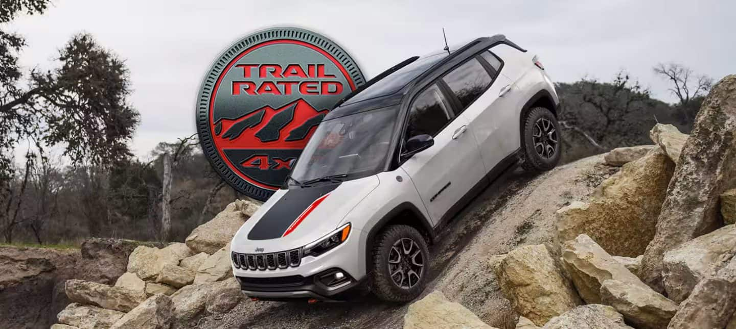 Un Jeep Compass Trailhawk 2024 descendiendo una colina muy empinada fuera de la carretera. El emblema Trail Rated 4x4.