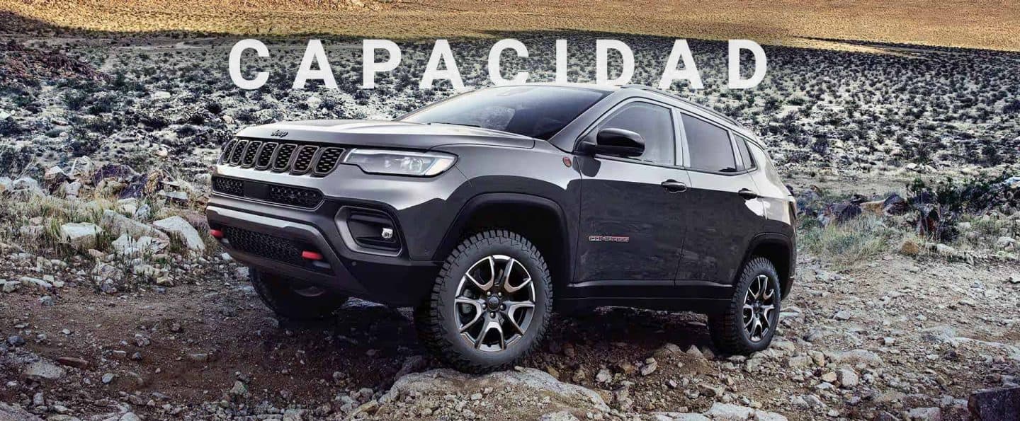 Un Jeep Compass Trailhawk 2024 atravesando rocas y piedras grandes y pequeñas en un camino fuera de la carretera. Capacidad.