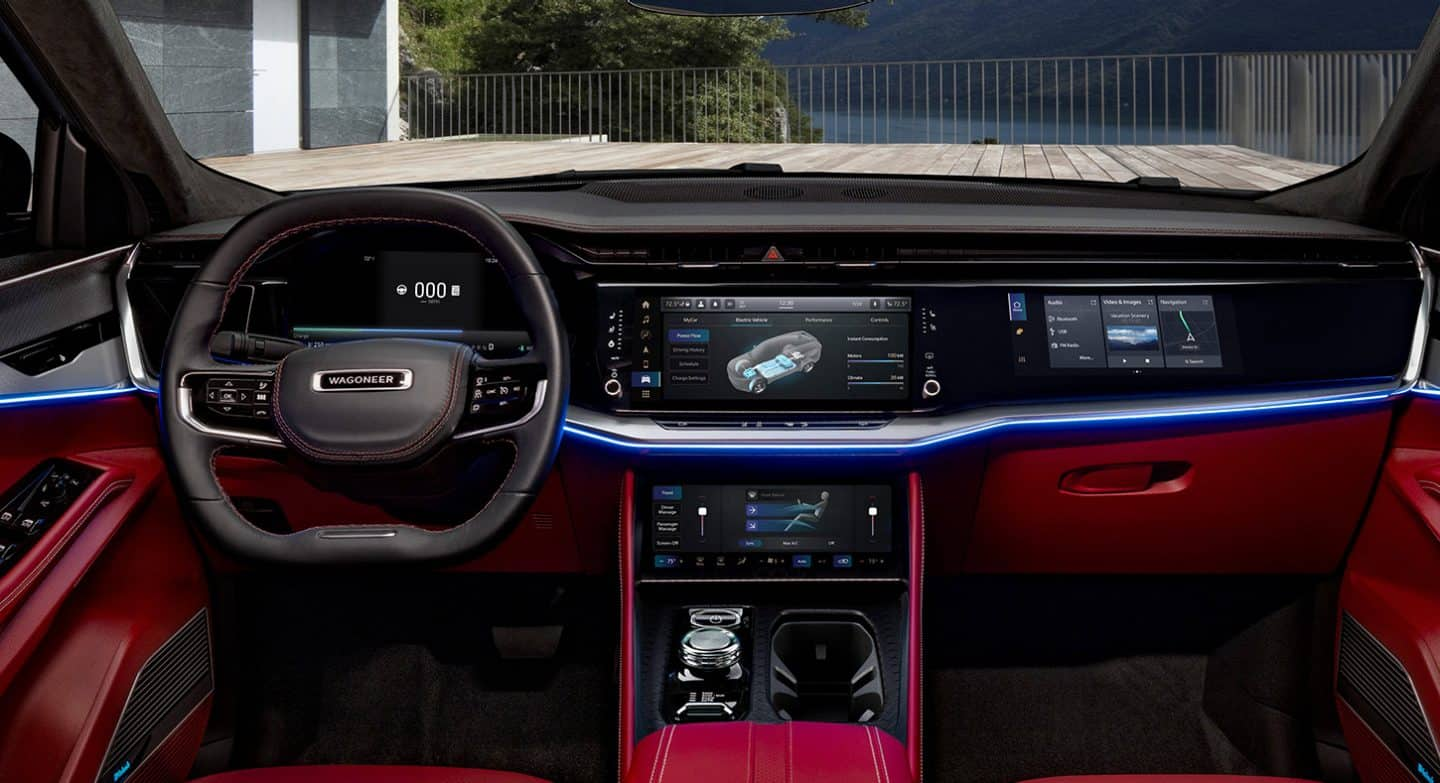 El interior del Jeep Wagoneer S Launch Edition 2024 que se centra en el tablero, incluido el volante, la pantalla digital del panel de instrumentos, la pantalla táctil Uconnect, los controles de la consola central y la pantalla interactiva para el pasajero delantero.