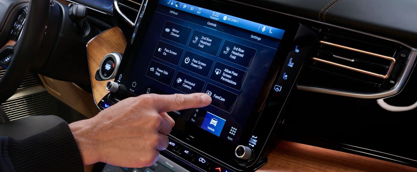 Pantalla táctil Uconnect en el Grand Wagoneer 2024 con diversos controles del vehículo mostrados, mientras el conductor selecciona la FamCam.