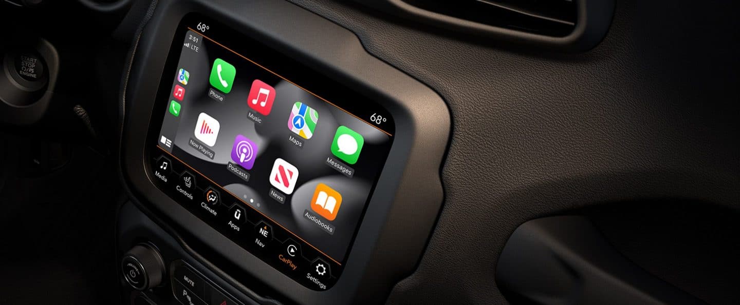 A close-up of the touchscreen in the 2023 Jeep Renegade with the driver's hand reaching for the phone icon on the screen.