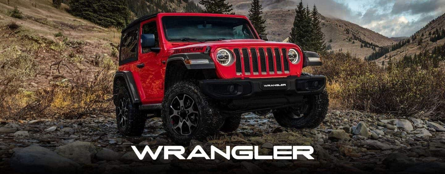 A red 2023 Jeep Wrangler Rubicon 4xe with its roof and doors removed, being driven down a steep hill off-road. Wrangler.