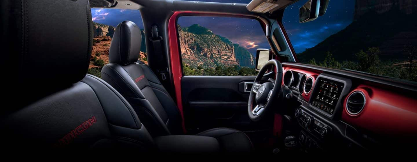 The front row of the 2023 Jeep Wrangler Rubicon with the steering wheel, dashboard and touchscreen included.