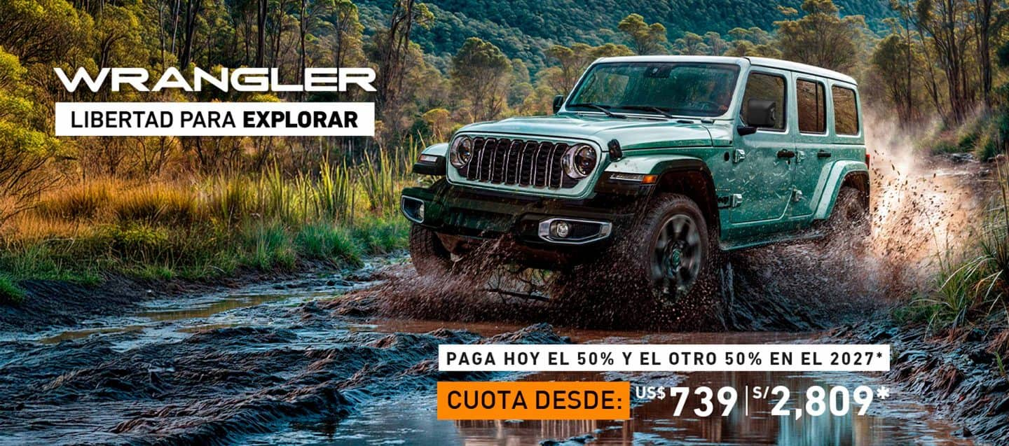 A 2024 Jeep Wrangler Rubicon 4xe with its doors and roof removed, being driven on a sandy trail off-road, with huge boulders on both sides.