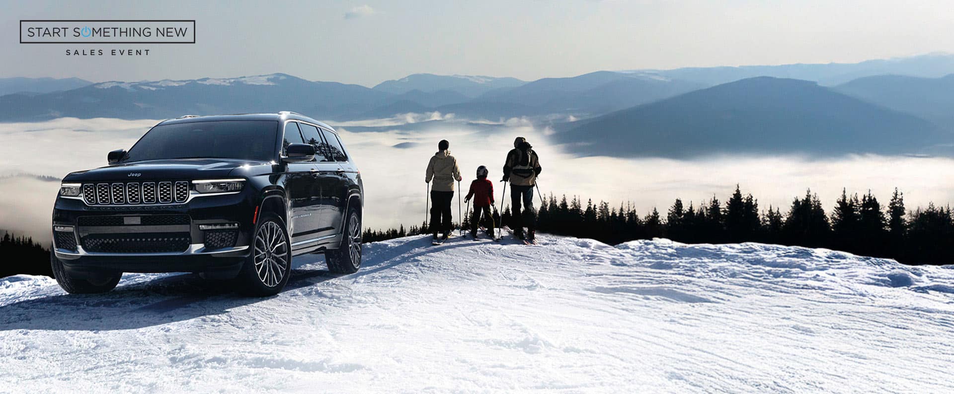 A black 2024 Jeep Grand Cherokee Summit Reserve parked on a snow-covered hill with a family of three in ski gear standing nearby and mountains in the background. Start Something New Sales Event logo. 