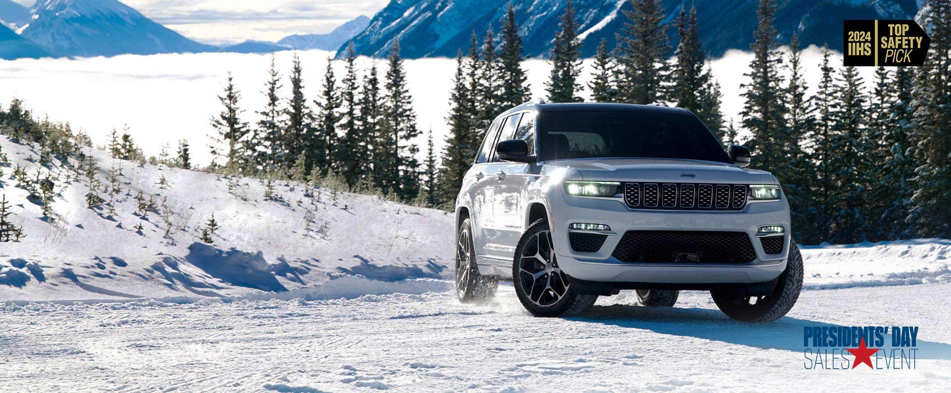 A white 2024 Jeep Grand Cherokee Summit Reserve traveling on a snow-covered road in the mountains. 2024 IIHS Top Safety Pick. President's day Event.