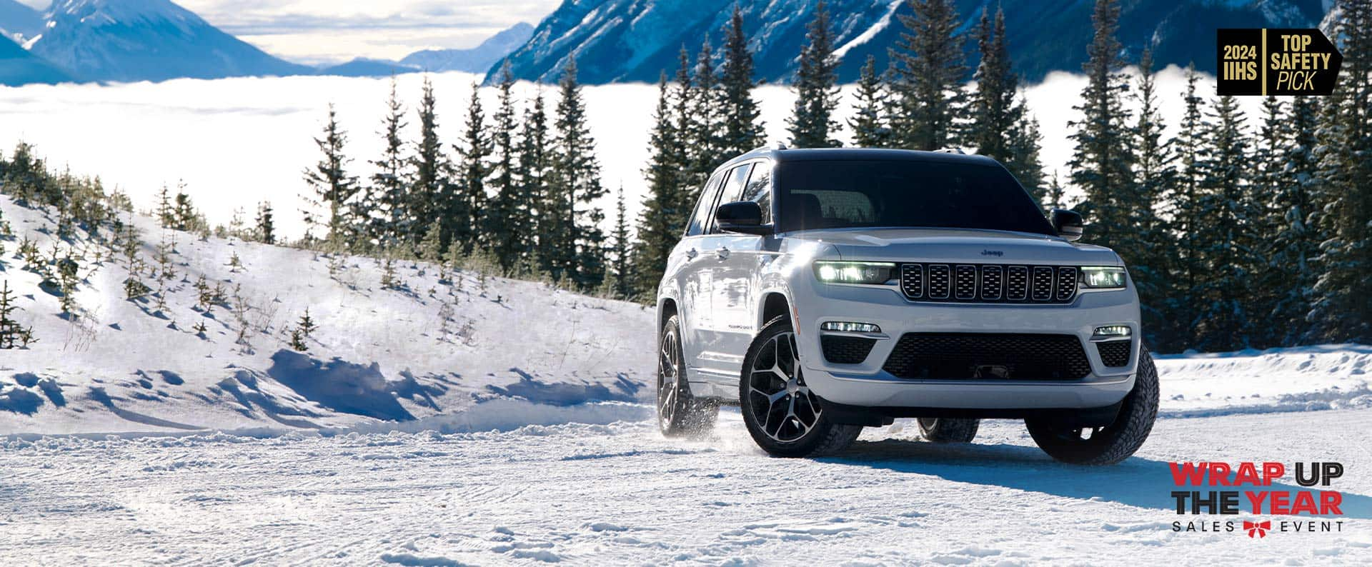 A white 2024 Jeep Grand Cherokee Summit Reserve traveling on a snow-covered road in the mountains. 2024 IIHS Top Safety Pick. Wrap Up the Year Sales Event.