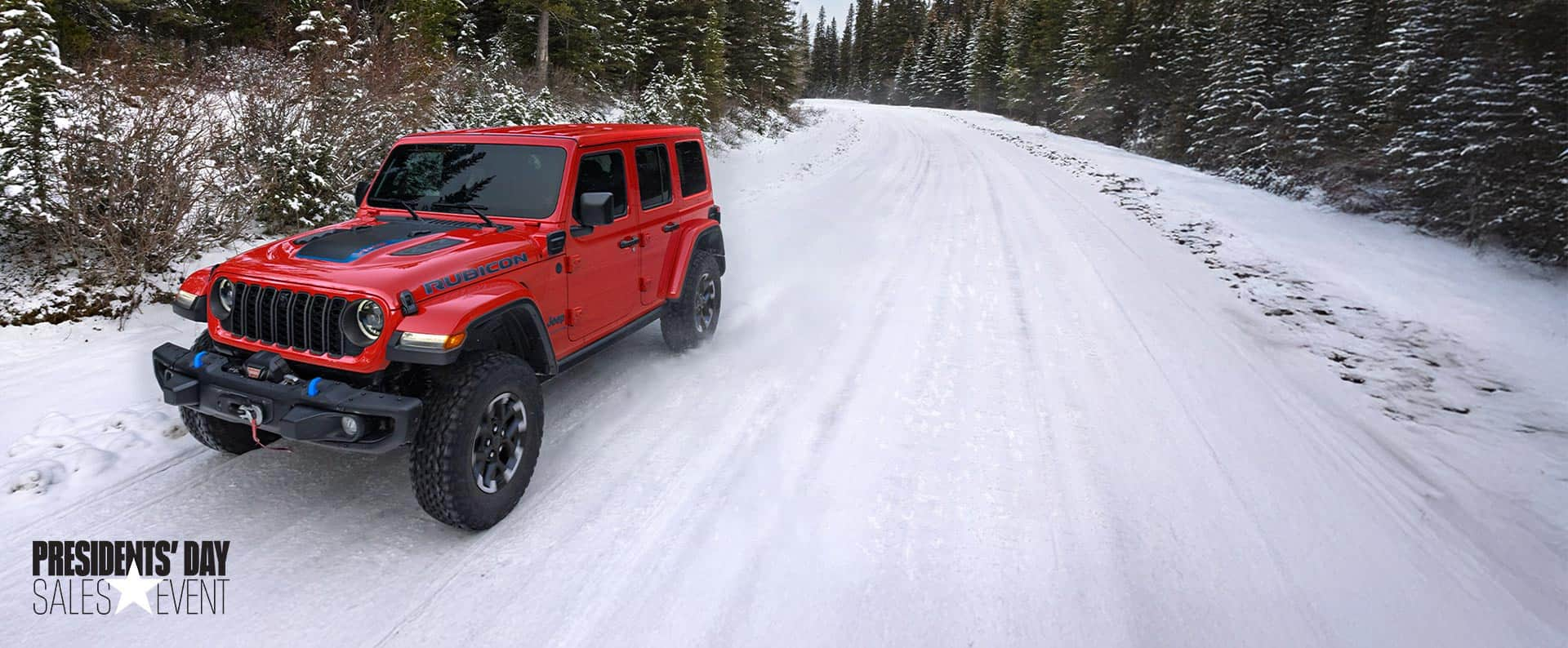 A red 2024 Jeep Wrangler Rubicon X 4xe traveling on a snow-covered road in a forest. President's day Event.