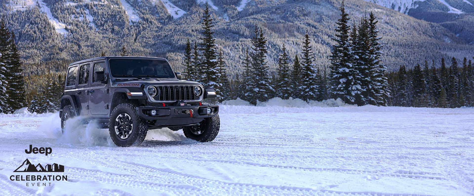 A gray 2024 Jeep Wrangler Rubicon traveling on a snow-covered trail in a forest. Celebration event.