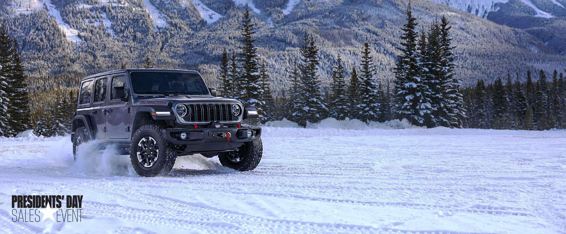 A gray 2024 Jeep Wrangler Rubicon traveling on a snow-covered trail in a forest. President's day event.  