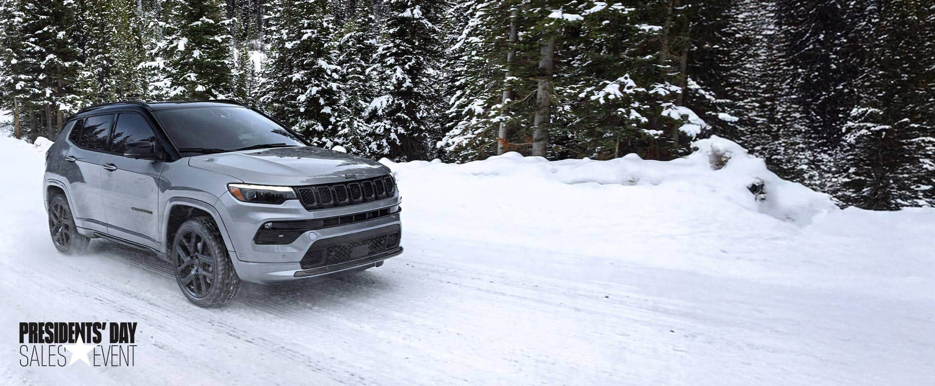 A silver 2025 Jeep Compass High Altitude, traveling on a snow-covered trail off-road in a forest. President's day Event.