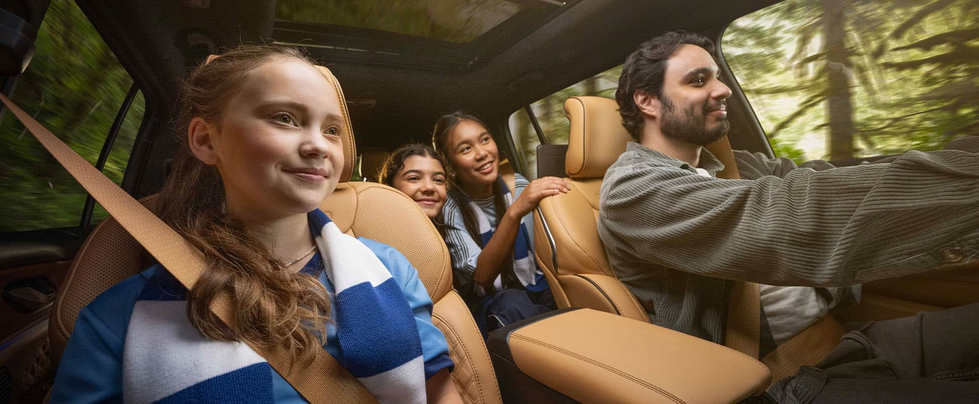 El interior del Jeep Grand Cherokee Summit 2025 con el conductor y tres pasajeros dentro: uno en el asiento del pasajero delantero y dos en la segunda fila.