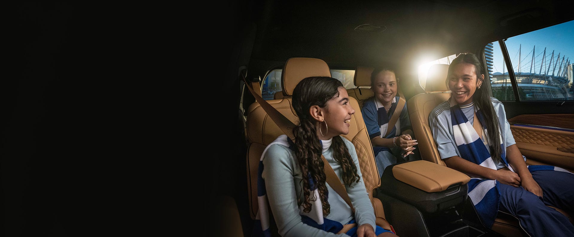 El interior del Jeep Grand Cherokee L Summit Reserve 2025 con dos niños sentados en la segunda fila y un niño sentado en la tercera fila.