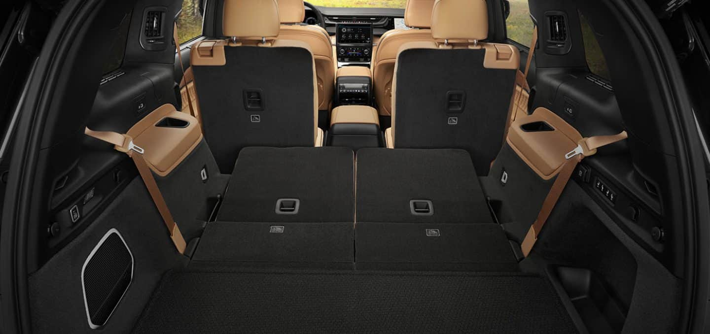 Display The cargo area of a 2025 Jeep Grand Cherokee L Summit Reserve with the second- and third-row seats folded down, demonstrating the large cargo area.