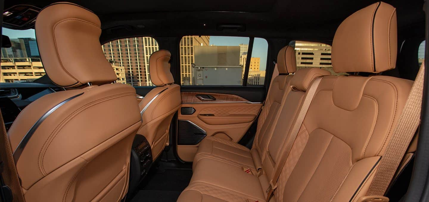 Display The second row of a 2025 Jeep Grand Cherokee Summit Reserve with highrise buildings in the background.