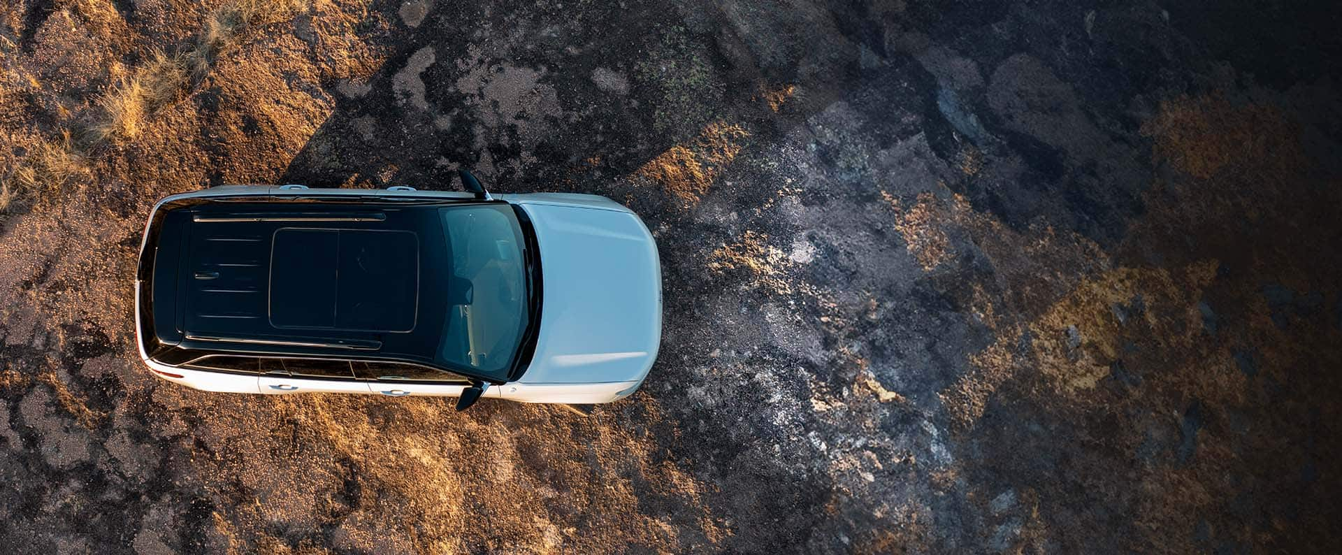 An overhead angle of a white 2025 Jeep Grand Cherokee Summit Reserve 4xe parked off-road.