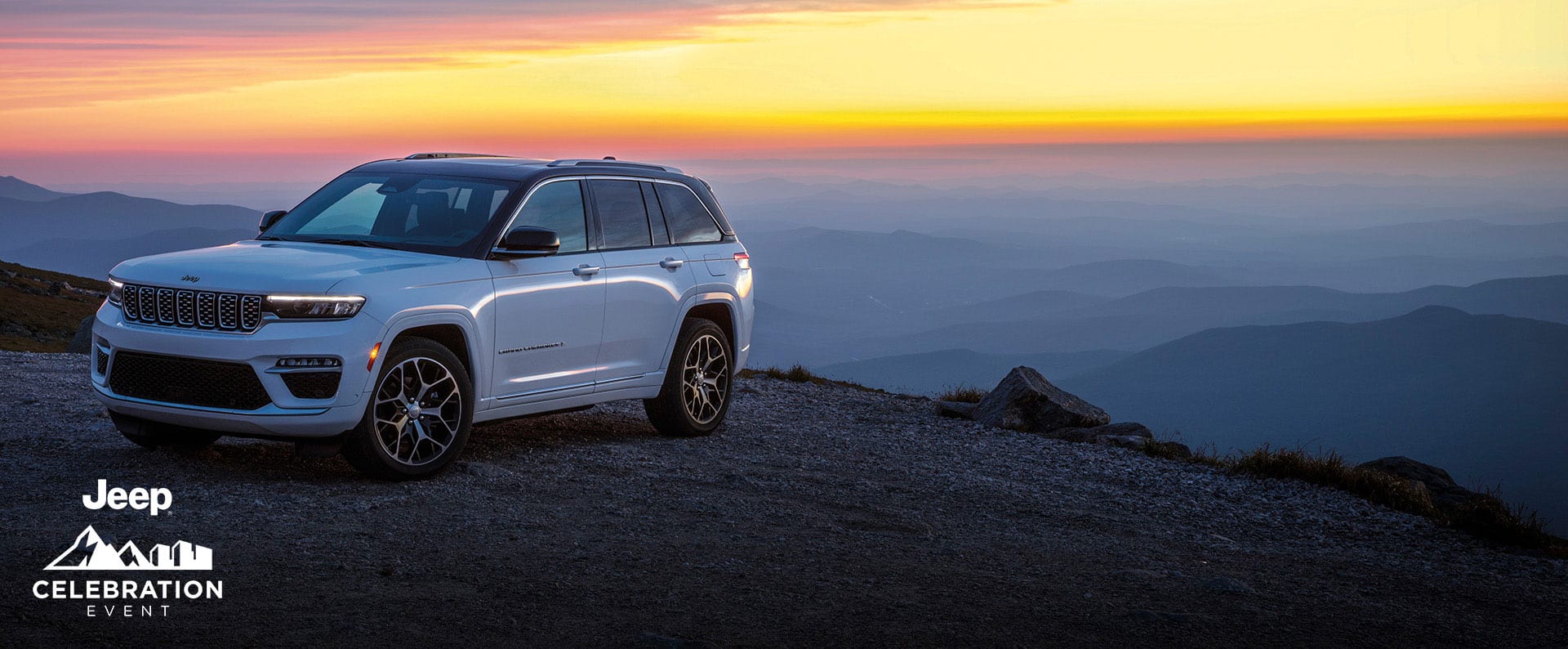 A white 2025 Jeep Grand Cherokee Summit Reserve parked near the edge of a cliff at sunset. Jeep Celebration Event.