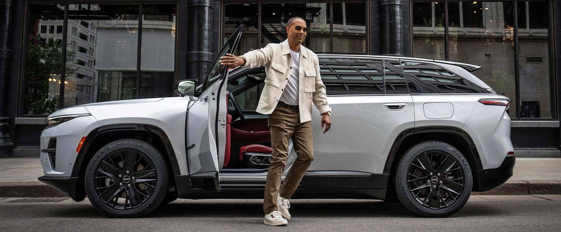 A man exiting the driver's door of a white 2025 Jeep Wagoneer S Launch Edition.