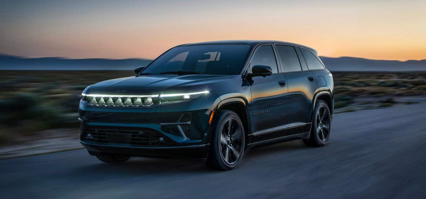 Display A black 2025 Jeep Wagoneer S Launch Edition traveling on a desert highway at dusk.