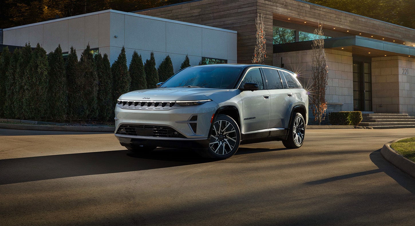 Un Jeep Wagoneer S Limited 2025 plateado en la entrada circular de un edificio comercial.