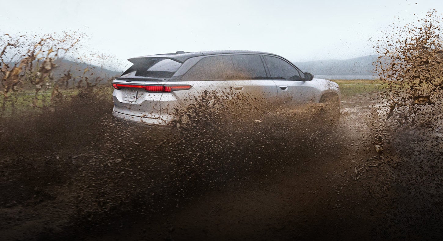 A silver 2025 Jeep Wagoneer S Launch Edition traveling through a mucky trail, kicking up mud as it goes.
