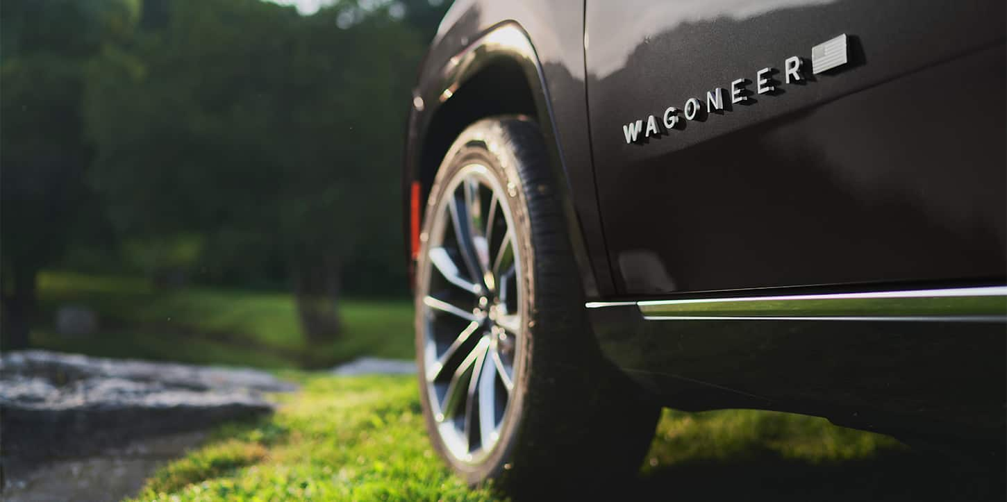 The exterior 'Wagoneer' badge on the driver's door of a black 2025 Jeep Wagoneer.