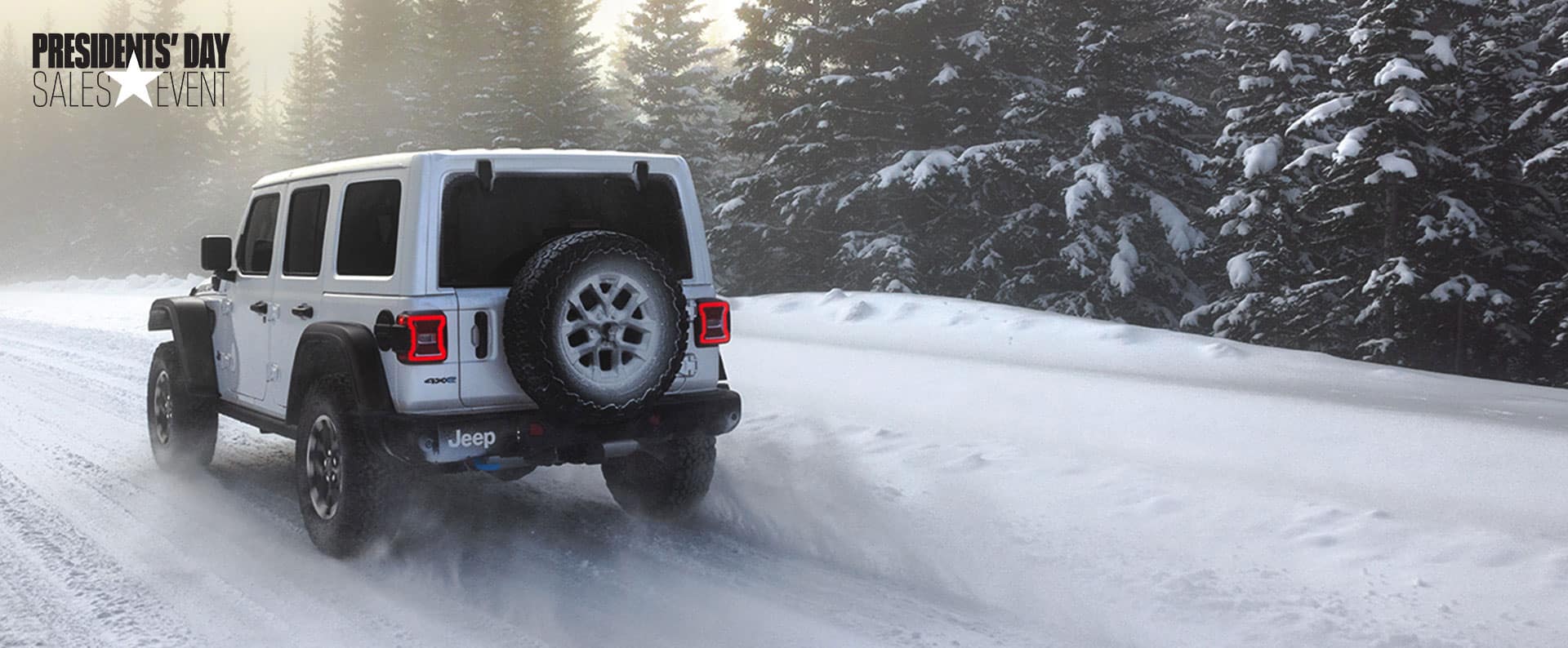 A white 2025 Jeep Wrangler Sports S 4xe traveling on a snow-covered trail in the mountains. President's day Event.