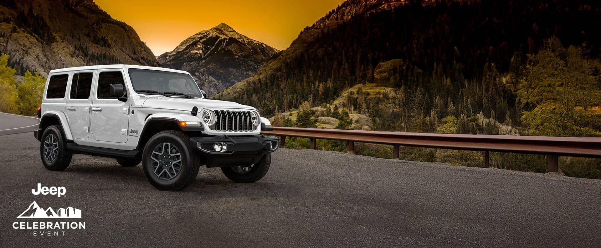 A passenger-side front angle of a white 2025 Jeep Wrangler Sahara parked on the shoulder of a highway in the mountains at sunset. Jeep Celebration Event.