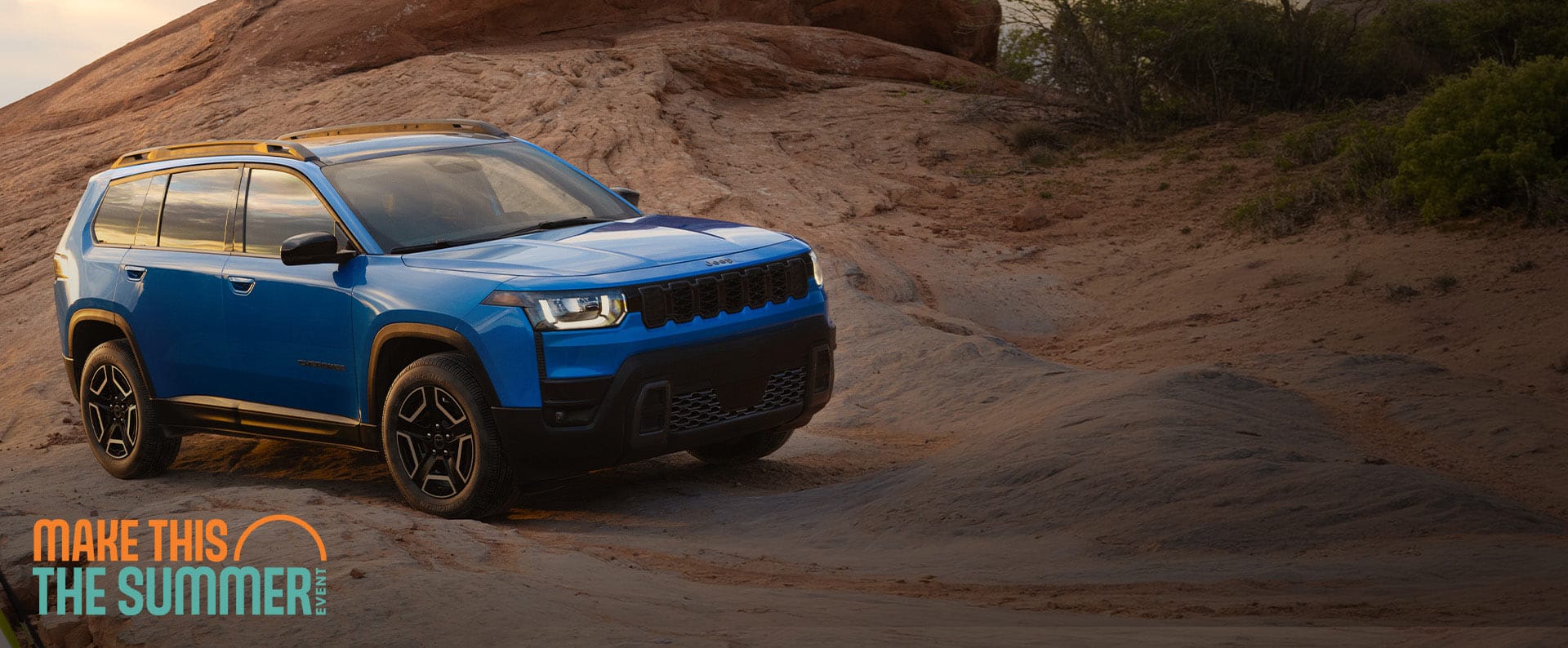 A blue 2026 Jeep Cherokee Laredo parked on a trail off-road. Make This The Summer Event.