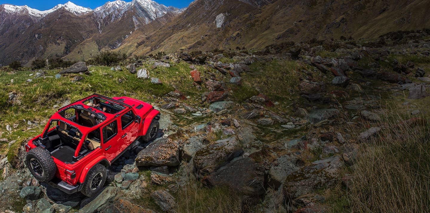 Jeep Wrangler Rubicon being driven on rocky, mountainous terrain.