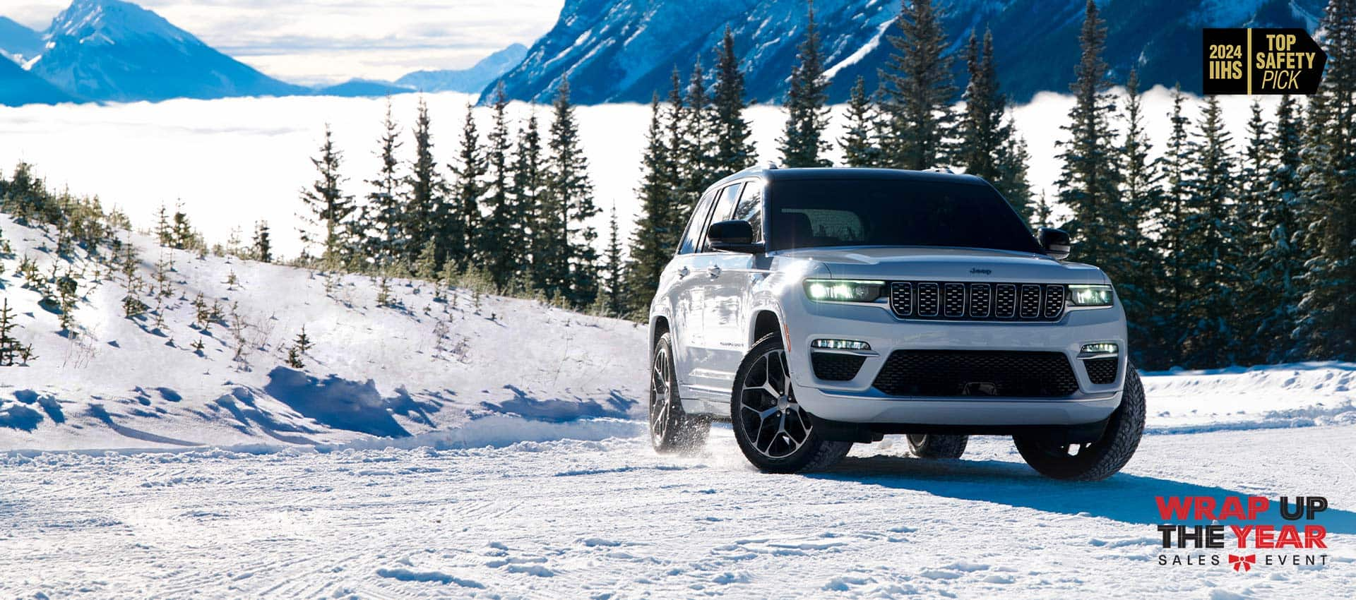 A white 2024 Jeep Grand Cherokee Summit Reserve traveling on a snow-covered road in the mountains. 2024 IIHS Top Safety Pick. Wrap Up the Year Sales Event.  