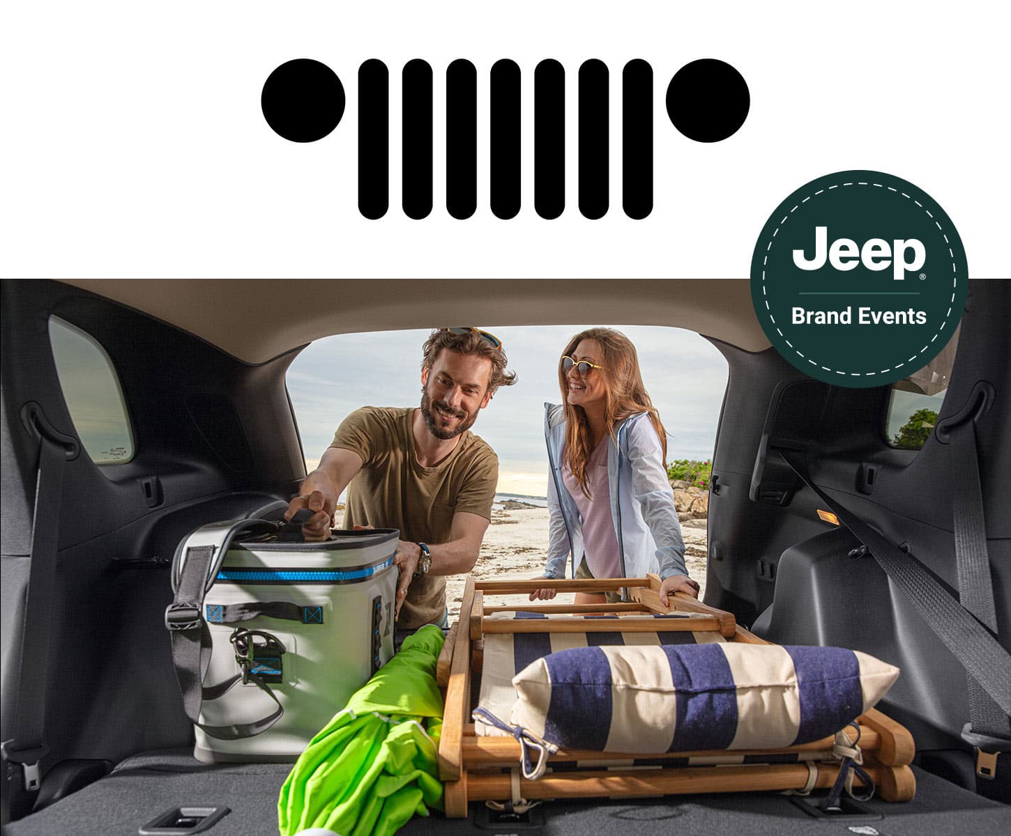 A couple removing beach equipment from the cargo area of a 2024 Jeep vehicle. Jeep Brand Events.