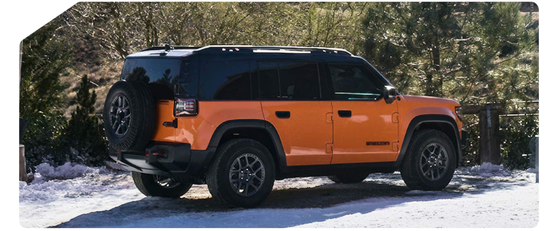 A passenger-side rear angle of an orange 2025 Jeep Recon preproduction model.