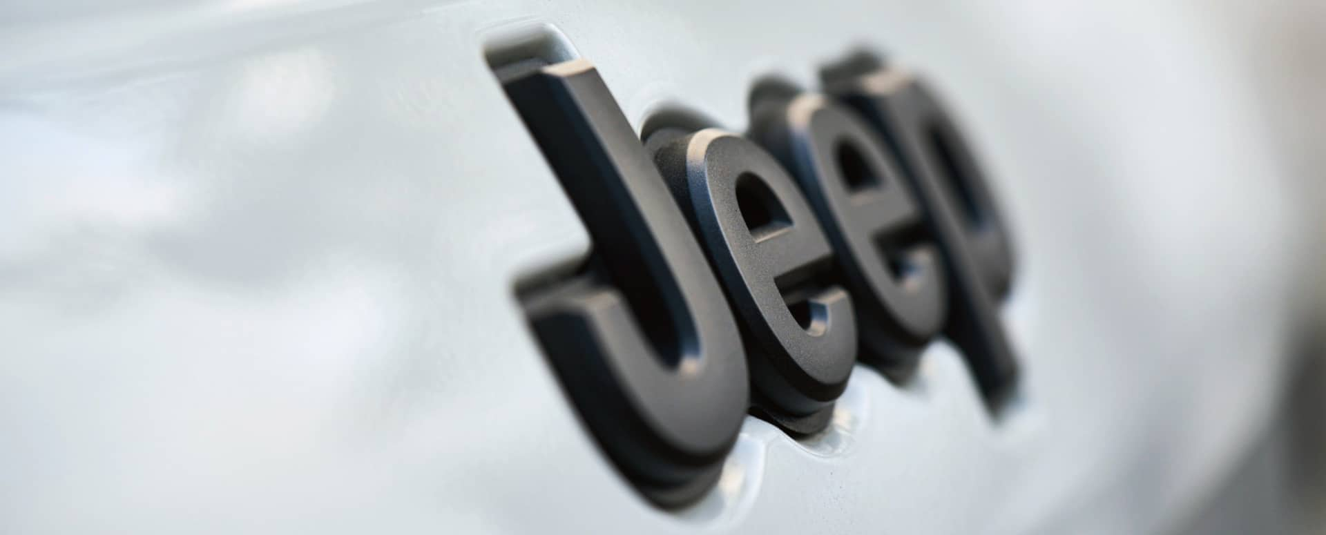 A close-up of the raised Jeep badge lettering on a Jeep Brand vehicle. 