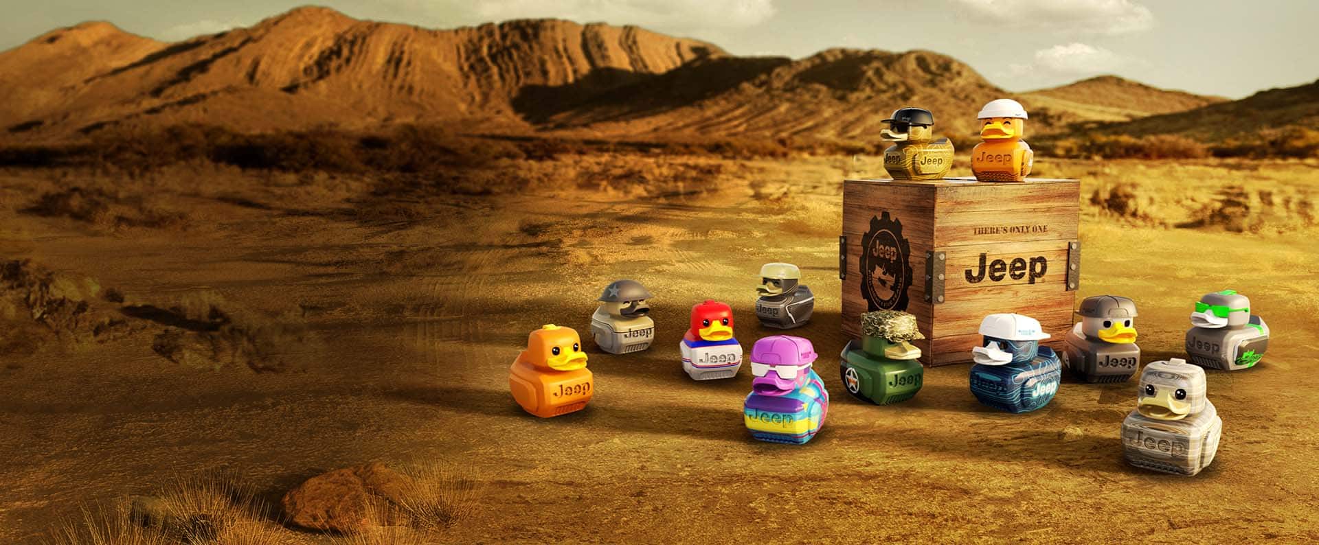 12 distinctly different Jeep ducks in the desert, scattered around a small wooden crate stamped with Jeep logos and symbols.