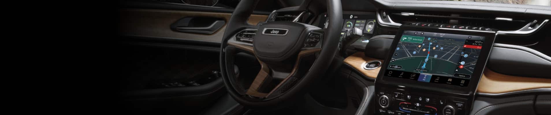 The steering wheel and Uconnect touchscreen in the 2025 Jeep Grand Cherokee.